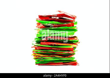 Stapel von Rot, Gelb und Grün Folie Kunststoff Snack Verpackungen. Ungesunde Nahrung, Recycling Konzept. Stockfoto