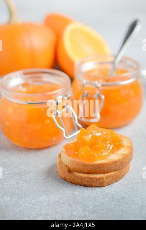 Hausgemachte Kürbis und Orange Konfitüre in Gläser auf einem grauen konkreten Hintergrund. Stockfoto