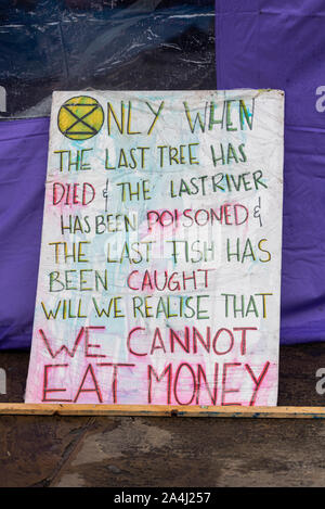 Aussterben Rebellion Morgendunst am Trafalgar Square, London, UK. Protest Camp. Plakat gegen den Kapitalismus Stockfoto