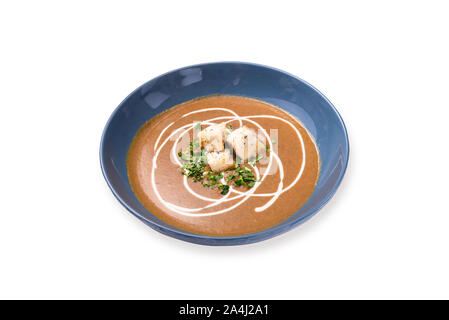 Gebratener Kürbis und Karotten Suppe mit Sahne und Kürbiskerne auf weißem Hintergrund. Stockfoto