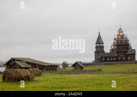 Karelien, Russland - 27. August 2019: Sunset Landschaft mit Blick auf die Verklärung Kirche und einem Bauernhof auf der Insel Kischi, Region Karelien, R Stockfoto