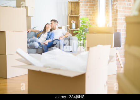 Junges Paar in Liebe entspannen auf dem Sofa sitzen im neuen Zuhause und lächelt glücklich für Umzug in neue Wohnung Stockfoto