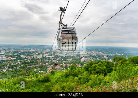 Almaty Kok Tobe Blue Hill Mountain Park mit Blick auf das Stadtbild und die bevorstehenden Seilbahnen an einem nebligen und trüben Tag Stockfoto