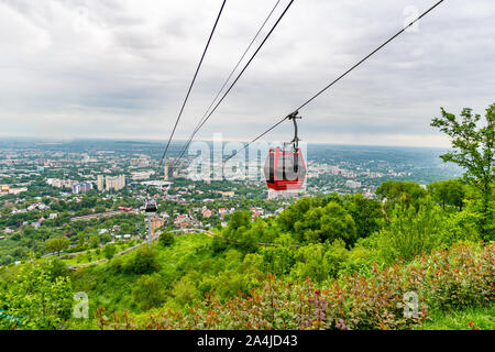 Almaty Kok Tobe Blue Hill Mountain Park mit Blick auf das Stadtbild und die bevorstehenden Seilbahnen an einem nebligen und trüben Tag Stockfoto