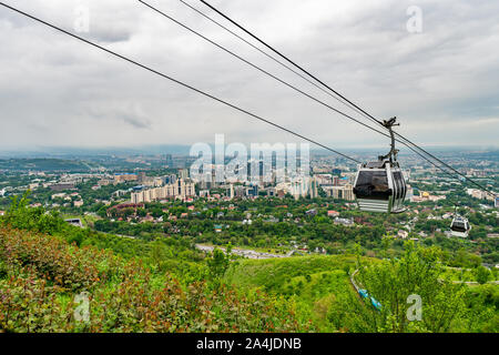 Almaty Kok Tobe Blue Hill Mountain Park mit Blick auf das Stadtbild und die bevorstehenden Seilbahnen an einem nebligen und trüben Tag Stockfoto