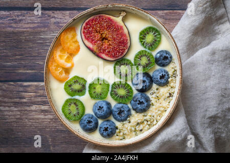 Eine frische, gesunde organische Joghurt smoothie Schale von oben gesehen mit einer Variation von frischen Früchten - Heidelbeeren, Kiwis, Feigen, Passionsfrucht und kumqu Stockfoto