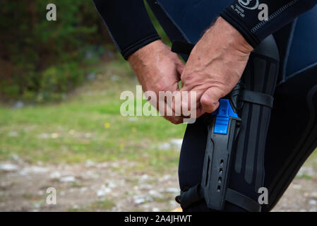 Paayanne See, Finnland - September 2019. Diver prüft Geräte in der Nähe des Sees. Männliche Taucher im Neoprenanzug überprüfen Ausrüstungen vor dem Eintauchen. Stockfoto