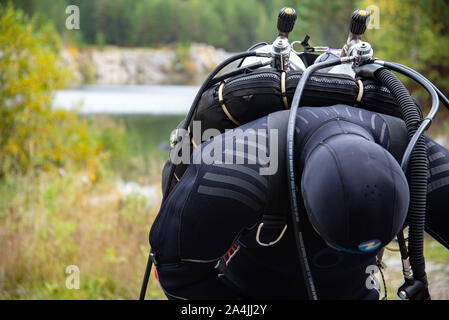 Paayanne See, Finnland - September 2019. Diver prüft Geräte in der Nähe des Sees. Männliche Taucher im Neoprenanzug überprüfen Ausrüstungen vor dem Eintauchen. Stockfoto