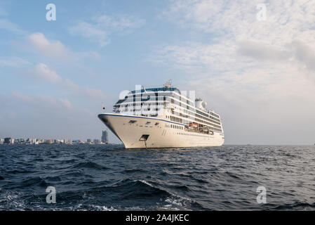 Male, Malediven - November 17, 2017: Oceania Cruises Nautica Kreuzfahrtschiff ist im äußeren Hafen der männlichen Insel verankert wie vom Boot aus gesehen in Maldiv Stockfoto