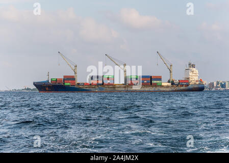 Male, Malediven - November 17, 2017: Container schiff PACIFIC VOYAGER Im äußeren Hafen der männlichen Insel vom Boot auf den Malediven, Indischer Ozean gesehen. Stockfoto