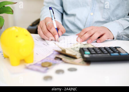 Bild der Person Geld Hinterlegung in einem gelben Sparschwein. Auf Hintergrund isoliert. Stockfoto