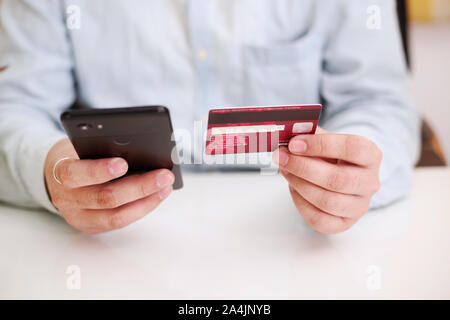 Bild von Close up Mann mit Smart Phone und Holding mit Kreditkarte online einkaufen. Online Zahlung Konzept. Stockfoto