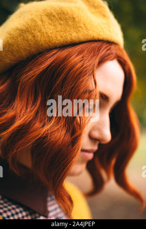 Eine schöne rothaarige Frau mit einem Curly Frisur im Park. Stockfoto