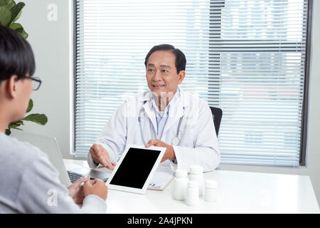 Leitender Arzt berät junge Patienten Stockfoto