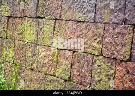 Nahaufnahme eines alten Moosbewachsenen stein Wand Textur bei Tageslicht Stockfoto