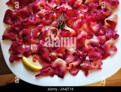 - Skandinavische Graved Lachs mariniert in Salz, Zucker und Rote Beete, serviert wie Carpaccio mit Zitrone und Dill Stockfoto