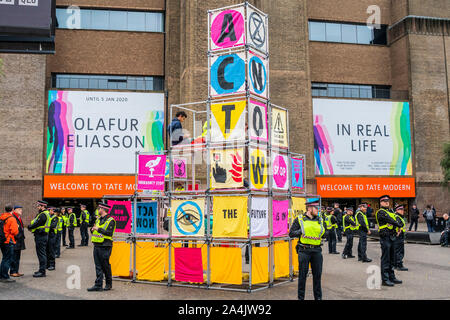 London, Großbritannien. 15 Okt, 2019. Aussterben Rebellion einrichten Strukturen outsde der Vorderseite des Tate Modern, wie in der Vorschau des Nam June Paik exhibitiongoes auf der Innenseite. Sie sind schnell von der Stadt London Polizei umgeben und mit Verhaftung gedroht, wenn sie nicht kommen. Credit: Guy Bell/Alamy leben Nachrichten Stockfoto