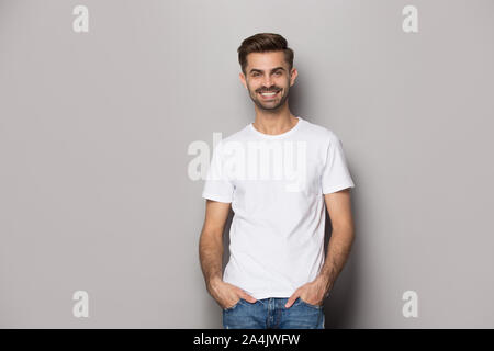 Lächelnd kaukasischen Mann auf Grau studio Hintergrund posiert Stockfoto