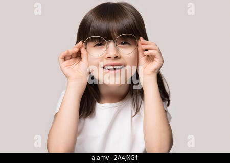 Kleines Mädchen versuchen am Tragen einer Brille korrigiert Sehvermögen Stockfoto