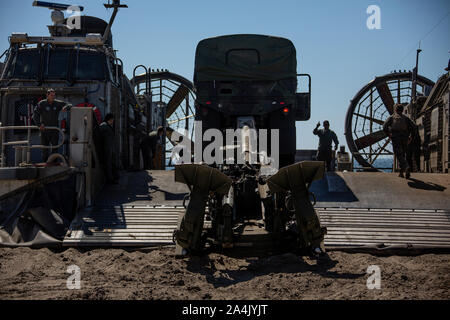 Us-Marines vom 3 Bataillon, 11 Marine Regiment, 1st Marine Division, offload Schwertransport und Artillerie Ausrüstung aus einer Landing Craft, Luftkissen mit Angriff Handwerk Einheit 5 auf Rote Strand, Camp Pendleton, Calif., Okt. 06, 2019. Naval Integration ist ein zentraler Bestandteil dessen, wer wir sind und wie wir arbeiten. Neben unsere Marine Gegenstücke enthält realistische einschlägige Ausbildung, die für eine wirksame globale U.S. Navy und Marine Corps. (U.S. Marine Corps Foto von Cpl. Mark Lowe II) Stockfoto