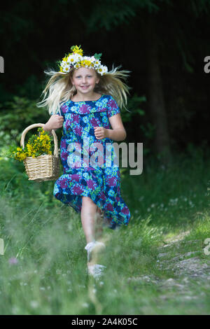 Porträt der jungen Mädchen mit Kranz, die in der Wiese Stockfoto