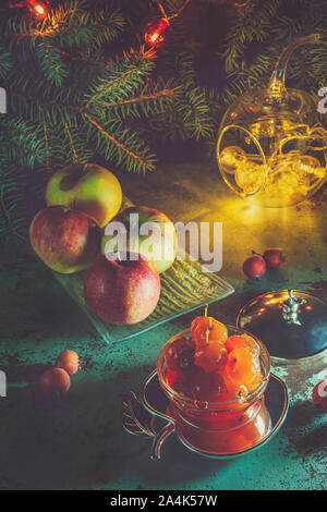 Apple Jam von kleinen Äpfel mit Mandeln in eine schöne Vase vor dem Hintergrund der Weihnachtsbaum. Stockfoto