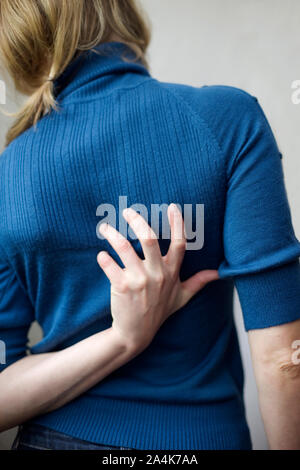 Itch. Insekt beißt. Frau Kratzer auf ihrem Rücken. Stockfoto