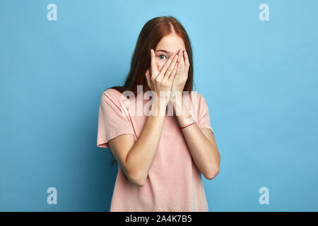 Angst Mädchen, die ihr Gesicht mit Palm betonte, Gefühl der Angst vor der stressigen situstion, schöne stilvolle Mädchen ihr Gesicht versteckt hinter Palmen. Nach oben p schließen Stockfoto