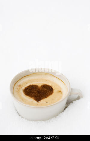 Tasse heiße Schokolade mit Herz im Schnee Stockfoto