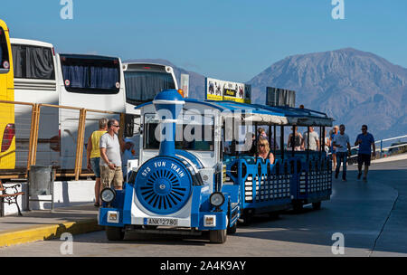 Agios Nikolaus, Kreta, Griechenland. Oktober 2019. Der Hafen von Agios Nikolaos, die tour bus Parkplätze für Busse und Reisebusse und der beliebten Straße Bahn Stockfoto