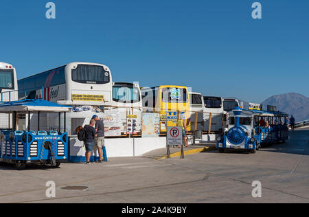 Agios Nikolaus, Kreta, Griechenland. Oktober 2019. Der Hafen von Agios Nikolaos, die tour bus Parkplätze für Busse und Reisebusse und der beliebten Straße Bahn Stockfoto