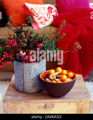 Heather im Blumentopf und einer Schale mit Obst und Kuchen auf dem Tisch Stockfoto