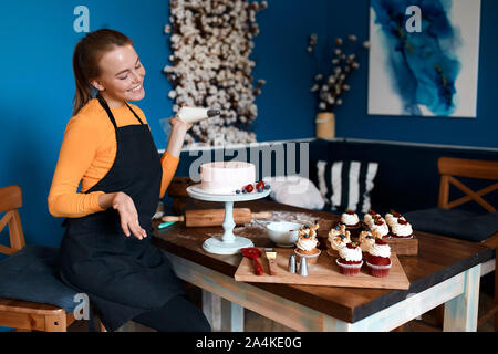 Positive charmante Chef an ihrem Haus gemacht Keks freuen, Nahaufnahme Foto, Glück, positives Gefühl und Emotion Stockfoto