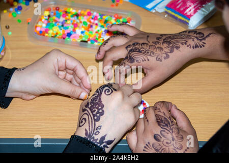 Sheffield, Großbritannien: 1 Aug 2016: Nahaufnahme der mehndi dekoriert Hände von zwei jungen Frauen, die Raupe Kunst an der St. Mary's Kirche Familie Spaß-Tag Stockfoto