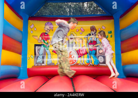 Sheffield, Großbritannien: 1 Aug 2016: Zwei Kinder springen auf einer Hüpfburg aufblasbare Spielzeug in St Mary's Church Family Fun Day Stockfoto