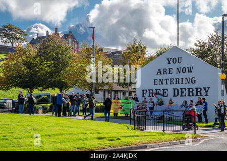 DERRY LONDONDERRY/NORDIRLAND - 12. OKTOBER 2019: Menschen gegen den Krieg vor der Free Derry Denkmal demonstrieren. Stockfoto
