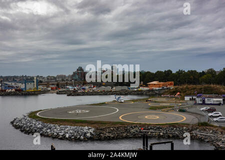 Victoria/Kanada -9/14/19: ein Hubschrauber auf einen Hubschrauberlandeplatz neben einem Kreuzfahrtschiffe im Hafen von Victoria, Kanada. Stockfoto