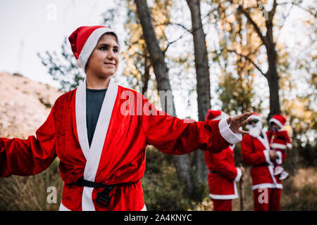 Junge zu Weihnachten Wandern und Genießen durch den Wald mit seiner Familie getarnt Stockfoto