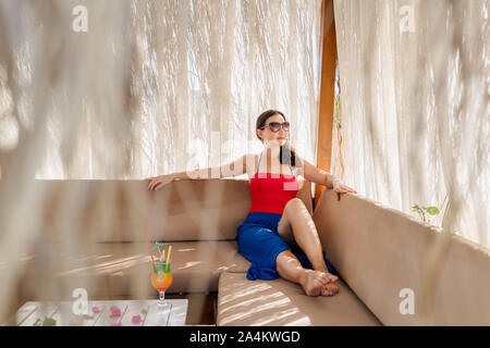 Junge Frau entspannen in einer Pergola auf einem Urlaub. Stockfoto