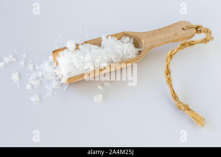 Salz Flocken in Holz- Schaufel auf weißem Hintergrund - Seitenansicht Stockfoto