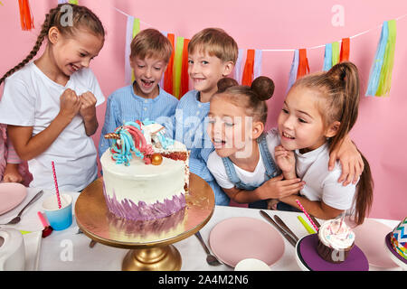 Glückliche Gruppe der Kinder im Blick der Geburtstagskuchen Freude, Kinder Desserts zu probieren. studio Shot Stockfoto