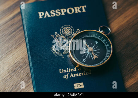 Ein goldener Kompass oben auf einem blauen amerikanischen Pass Stockfoto