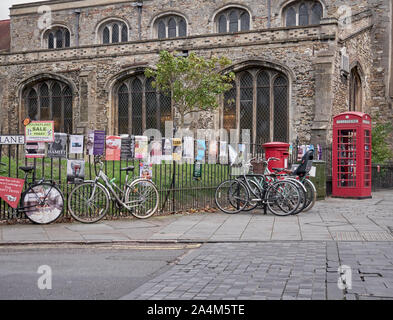 Cambridge, UK - Oktober 9, 2019: Fahrräder gegen den Zaun mit einer Menge Poster geparkt. Stockfoto