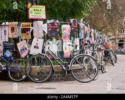 Cambridge, UK - Oktober 9, 2019: Fahrräder gegen den Zaun mit einer Menge Poster geparkt. Stockfoto