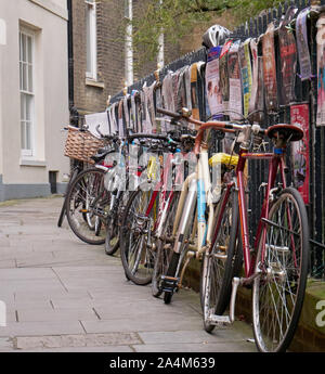 Cambridge, UK - Oktober 9, 2019: Fahrräder gegen den Zaun mit einer Menge Poster geparkt. Stockfoto