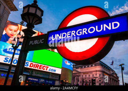 LONDON, UK - 16. JUNI 2013: Beleuchtete London U-Schild am Piccadilly Circus Station Eingang mit LED-Werbung Anzeige im Hinterg Stockfoto