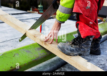 Ein Mann Sägen eine Planke in Norwegen Stockfoto