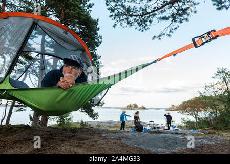 Der Mensch ruht in der Hängematte am Seeufer Stockfoto