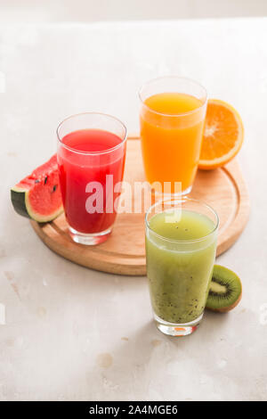 Frische Säfte Smoothie drei Glas Rot Grün Orange tropische Früchte Wassermelone, Kiwi, Orange. Selektiver Fokus Stockfoto