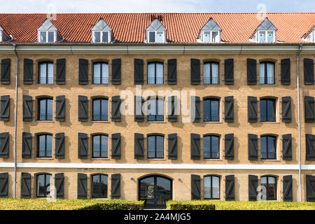 Muster von mehreren geöffneten Fenstern mit Fensterläden in einem großen Wohnhaus auf einem sonnigen Tag gebildet. Architektur Stockfoto